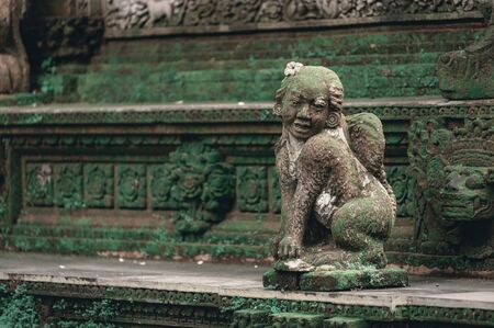 Sculptures of gods and demons carved from stone. Decor and decoration of ancient Hindu temples. Monkey Forest, a sacred temple complex in Ubud on the island of Bali, Indonesia.の写真素材