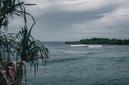 Tropical seascape. Ocean, waves and cloud blue sky. Travel to the tropics. Sandy beach and beautiful views splashing waves and nature. Bali Island. Toned.の写真素材