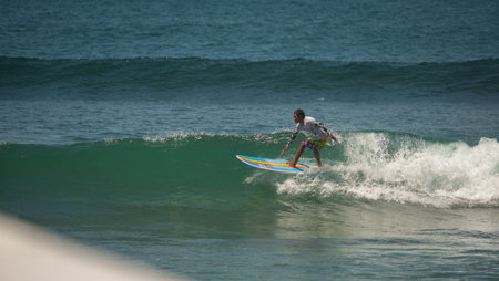 BALI, INDONESIA-MARCH 2020: Young people ride on short boards, perform tricks on the waves. Extreme...