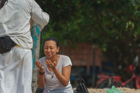 BALI, INDONESIA-APRIL, 2020: Traditional Balinese blessing ceremony by ocean, featuring newlyweds...