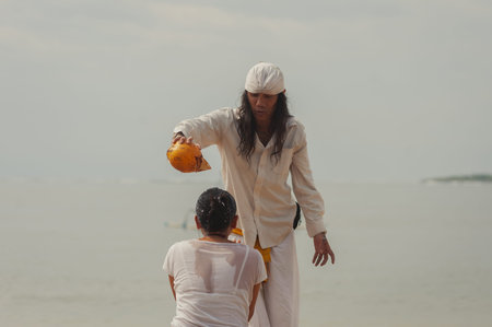 BALI, INDONESIA-APRIL, 2020: Traditional Balinese blessing ceremony by ocean, featuring newlyweds...