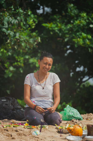 BALI, INDONESIA-APRIL, 2020: Traditional Balinese blessing ceremony by ocean, featuring newlyweds and an elder, shaman, monk or clergyman. Priest conduct the ceremony on the shore. Soft focus.のeditorial素材