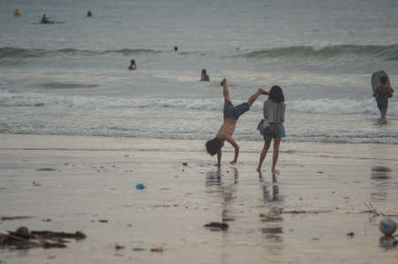 KUTA, INDONESIA - SPRING, 2020: Active vacation on the beach Semenyak, Jimbaran. Beach holidays and entertainment at sea, tourists and residents relax on the beach. Travel to Asia.のeditorial素材