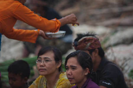 BALI, INDONESIA-APRIL, 2020: Traditional Balinese blessing ceremony by ocean elder, shaman, monk or clergyman. Priest conduct the ceremony on shore. Soft focus.のeditorial素材