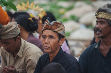BALI, INDONESIA-APRIL, 2020: Traditional Balinese blessing ceremony by ocean elder, shaman, monk or clergyman. Priest conduct the ceremony on shore. Soft focus.のeditorial素材