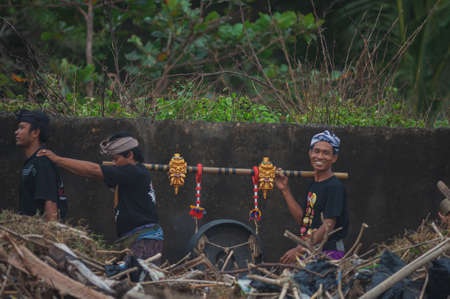 BALI, INDONESIA-APRIL, 2020: Traditional Balinese blessing ceremony by ocean elder, shaman, monk or clergyman. Priest conduct the ceremony on shore. Soft focus.のeditorial素材