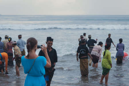 BALI, INDONESIA-APRIL, 2020: Traditional Balinese blessing ceremony by ocean elder, shaman, monk or clergyman. Priest conduct the ceremony on shore. Soft focus.のeditorial素材