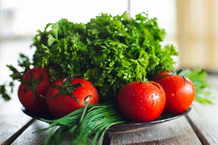 Fresh bright vegetables and herbs on a wooden table. Harvest on a rustic table. Ingredients for salads and vegetable dishes. Vegetarian.の写真素材