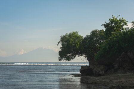 Tropical seascape. Ocean, waves and cloud blue sky. Travel to the tropics. Sandy beach and beautiful views splashing waves and nature. Bali Island. Toned.の写真素材