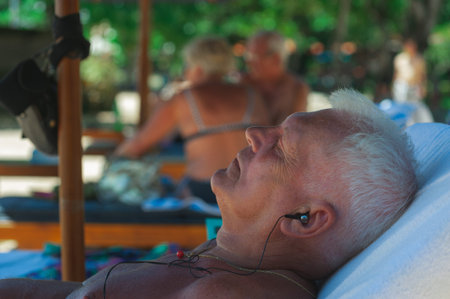 NUSA DUA, BALI, INDONESIA-SPRING, 2020: Vacationing young people are sunbathing Nusa Dua sandy...