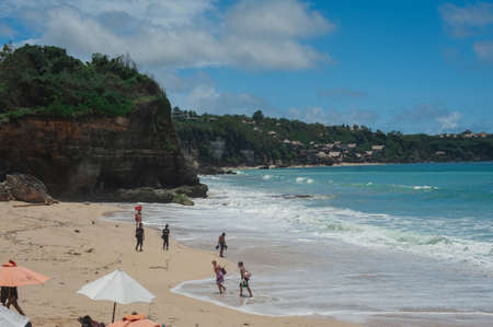 KUTA, BALI - APRIL, 2020: Tropical seascape. Ocean, waves and cloud blue sky. Travel to the tropics. Sandy beach and beautiful views splashing waves and nature. Bali Island. Toned.のeditorial素材