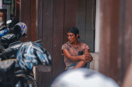 KUTA, BALI, INDONESIA-APRIL, 2020: Indonesians locals and street market employees sell souvenirs, cheap clothes, and food. Environment and society. Poverty and cheap goods. Travel to Asia.のeditorial素材