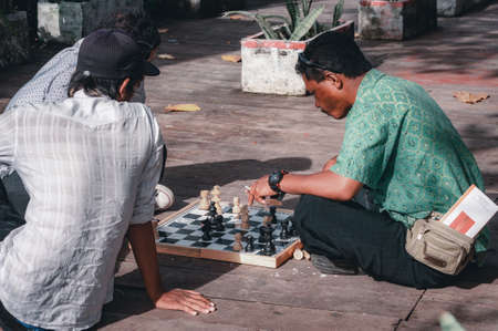 KUTA, BALI, INDONESIA-APRIL, 2020: Indonesians locals and street market employees sell souvenirs, cheap clothes, and food. Environment and society. Poverty and cheap goods. Travel to Asia.のeditorial素材