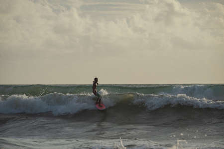 BALI, INDONESIA-MARCH 2020: Young people ride on short boards on the waves. Extreme sports and hobbies. Ocean waves. Soft focus and blurry photos while moving.のeditorial素材