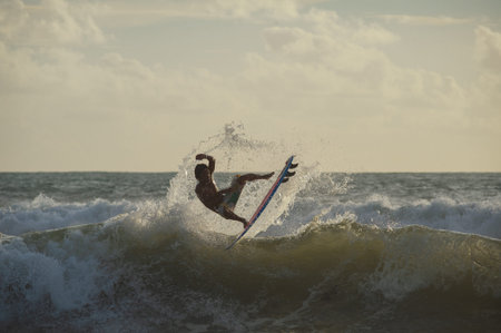 BALI, INDONESIA-MARCH 2020: Young people ride on short boards on the waves. Extreme jump, sports and...