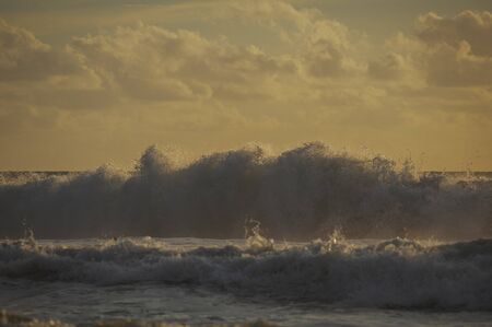 Magical dramatic sunset on a tropical beach. Seascape, ocean waves and bright clouds in the sky. Golden hour. Rest on the seashore, beach vacation. Concept.の写真素材