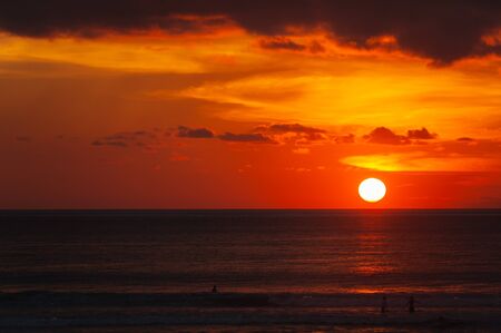 Tropical seascape. Stunning dramatic sunset over the ocean. Huge cumulus clouds colored by the setting sun. Beach holidays with sea views in the evening.の写真素材