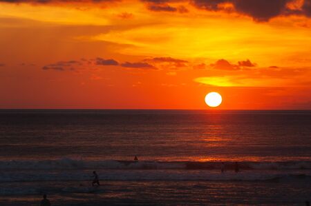 Tropical seascape. Stunning dramatic sunset over the ocean. Huge cumulus clouds colored by the setting sun. Beach holidays with sea views in the evening.の写真素材