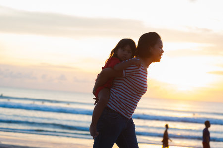 KUTA, INDONESIA - SPRING, 2020: Active vacation on the beach Semenyak, Jimbaran. Beach holidays and fun at sea, tourists and residents walk on the beach. Travel to Asia.のeditorial素材