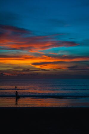 Tropical seascape. Stunning dramatic sunset over the ocean. Huge cumulus clouds colored by the setting sun. Beach holidays with sea views in the evening.の写真素材