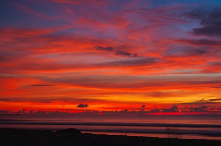 Tropical seascape. Stunning dramatic sunset over the ocean. Huge cumulus clouds colored by the setting sun. Beach holidays with sea views in the evening.の写真素材