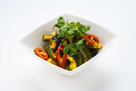 Traditional oriental salad of fresh vegetables in a deep white bowl on a white background, isolate.の写真素材