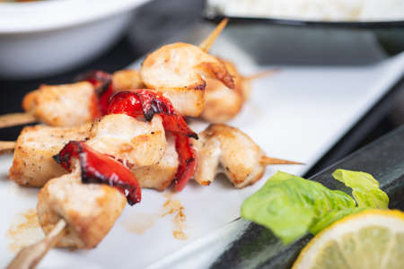 Traditional, oriental and Asian kebabs on a wooden skewer of grilled chicken pieces boiled rice as a garnish.の写真素材