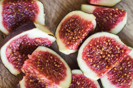 Pieces of fresh figs on a wooden board. Vegetables and fruits.の写真素材