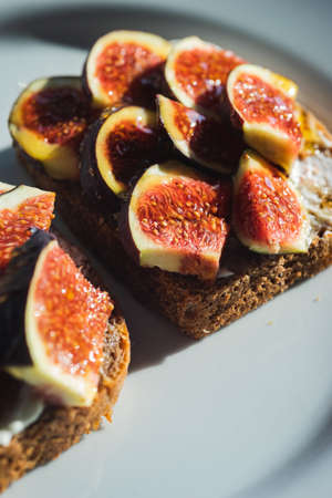 Fig pieces with cheese on rustic bread.の写真素材