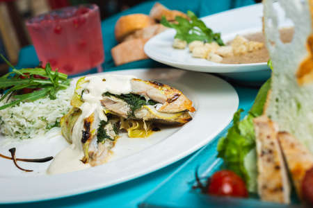 Fillet of white fish sea bass, cod stuffed with greens and rice on the table in the restaurant.の写真素材