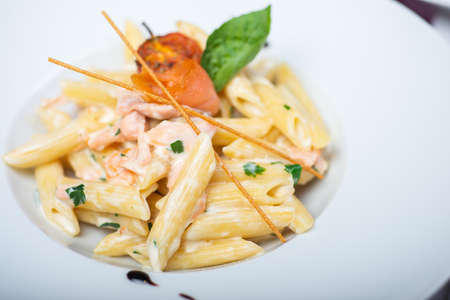 Traditional Italian pasta penne with salmon and creamy sauce.の写真素材