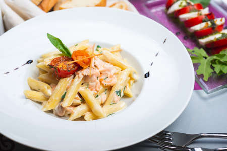 Traditional Italian pasta penne with salmon and creamy sauce.の写真素材