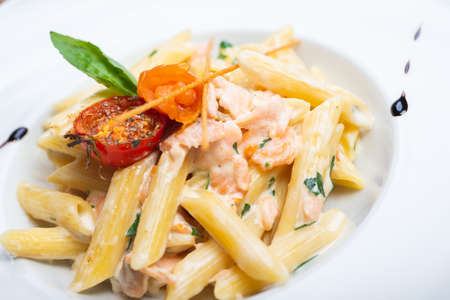 Traditional Italian pasta penne with salmon and creamy sauce.の写真素材