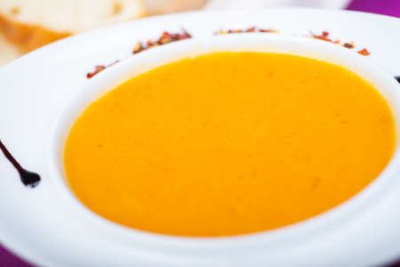 Lentil soup in a white plate on the table in a restaurantの写真素材