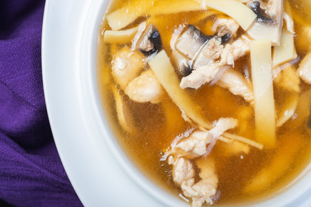 Traditional soup with meat broth in a white plate on a table in a restaurant. Complete and varied food. Soft focus and beautiful bokeh. Complex lunch.の写真素材