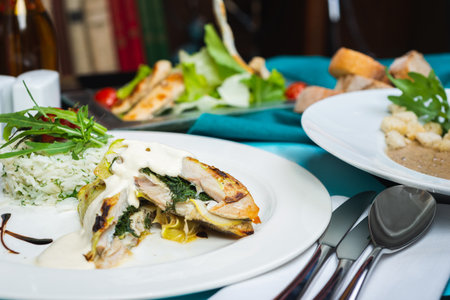 Fillet of white fish sea bass, cod stuffed with greens and rice on the table in the restaurant, served on the table for guests. Good nutrition, healthy food. Soft focus.の写真素材