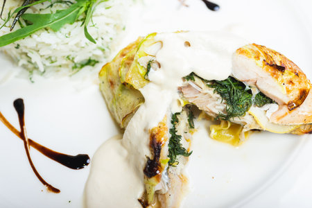 Fillet of white fish sea bass, cod stuffed with greens and rice on the table in the restaurant, served on the table for guests. Good nutrition, healthy food. Soft focus.の写真素材
