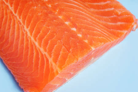 Fillet of red fish on a blue plastic cutting board.の写真素材