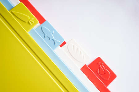 Multicolored bright plastic boards for cutting vegetables, bread, meat and other products on a white background.の写真素材