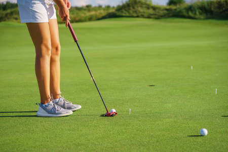 Beautiful tanned legs of a golfer girl on the golf course.の写真素材