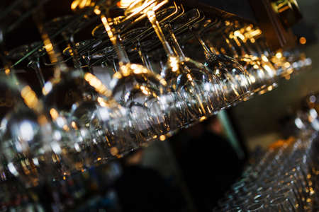 Clean wine glasses prepared by bartender and hung on the bar at a restaurant or cafe.の写真素材