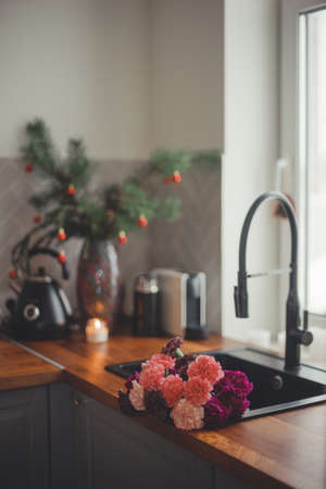 Cozy home lifestyle: wooden table top with beautiful carnation flowers and Christmas decorations.の写真素材