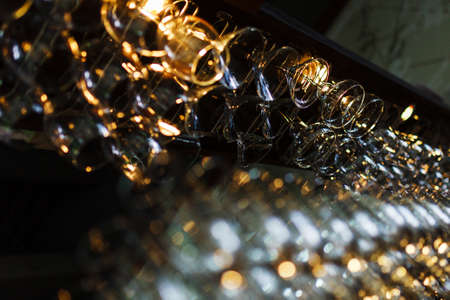 Clean wine glasses prepared by bartender and hung on the bar at a restaurant or cafe. Glasses prepared for a party at the bar.の写真素材