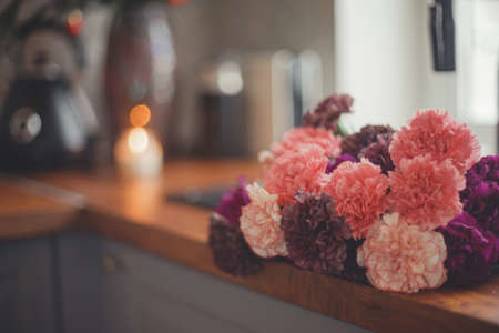 Cozy home lifestyle: wooden table top with beautiful carnation flowers and Christmas decorations.の写真素材