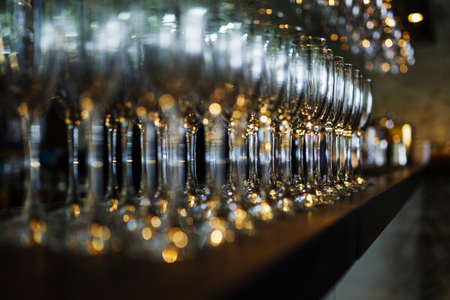 Clean wine glasses prepared by bartender and hung on the bar at a restaurant or cafe.の写真素材