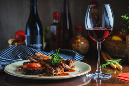 Fried ribs with a glass of red wine on a table in a restaurant close-upの写真素材