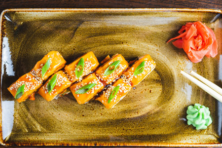 Traditional Japanese rolls with salmon fish, eel, seafood on a plate with wooden chopsticksの写真素材