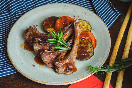 Fried ribs with a glass of red wine on a table in a restaurant close-upの写真素材