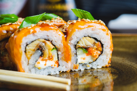 Traditional Japanese rolls with salmon fish, eel, seafood on a plate with wooden chopsticksの写真素材