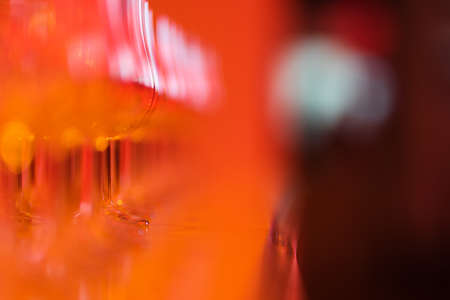 Empty classic whiskey glasses on the bar in a bright red glowの写真素材